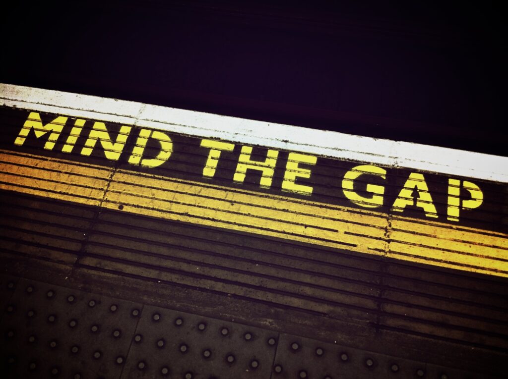 Mind the Gap Schriftzug auf einem U-Bahn-Bahnsteig
