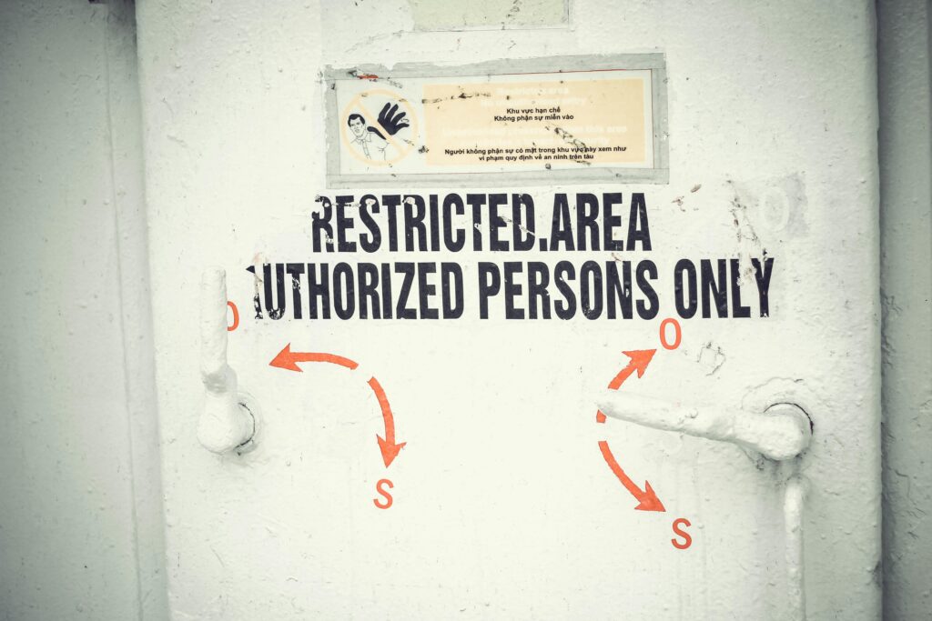 Tuer mit Hinweisschild Restricted Area, Authorized Persons Only